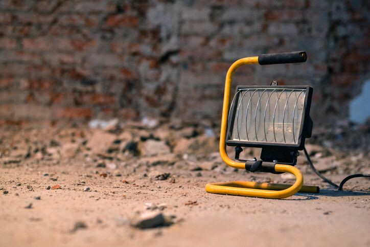 small yellow heater in front of internal brick wall
