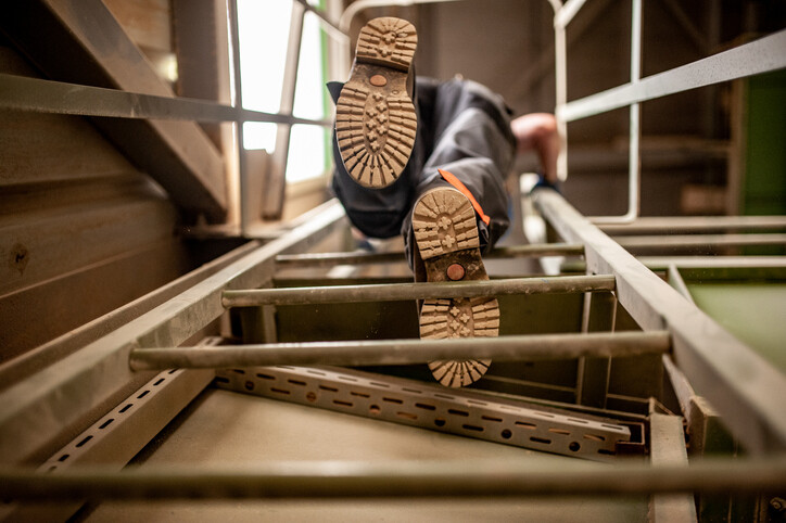 view from below of person climbing ladder