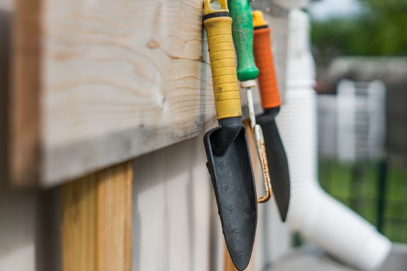 gardening-tools-hanging-on-garden-fence