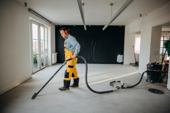 Man vacuuming concrete floor