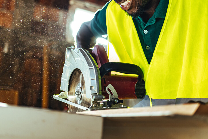Man using circular saw for cutting board.