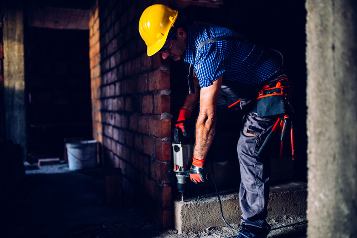 man using heavy duty drill on concrete