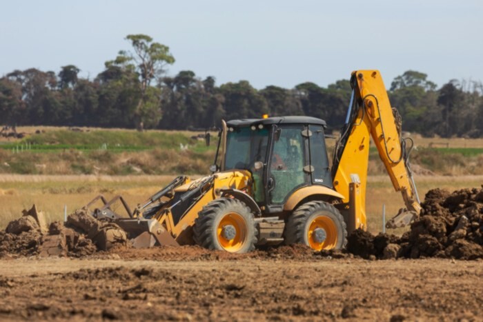 yellow digger on field