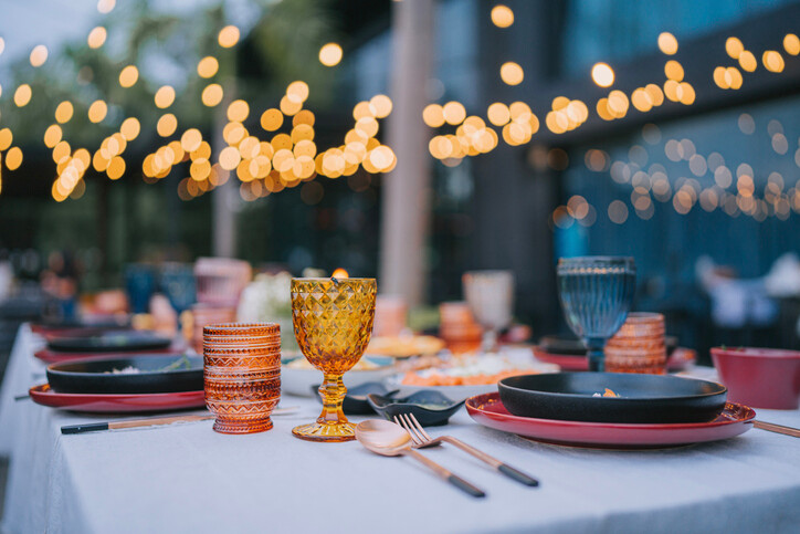 Set table and faint lighting at eveing outdoor dinner party