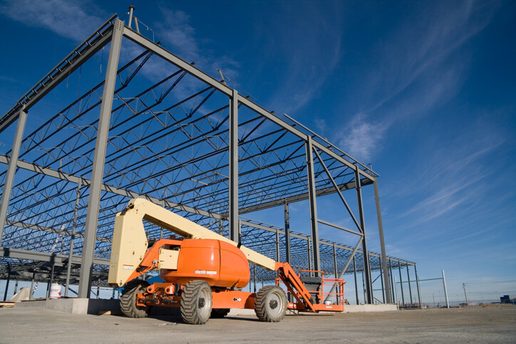 Stowed boom lift by frame for warehouse under construction