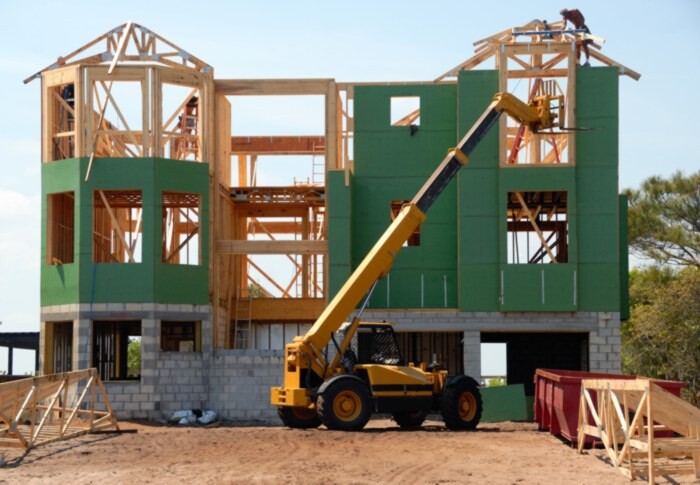 Telehandler working on house.