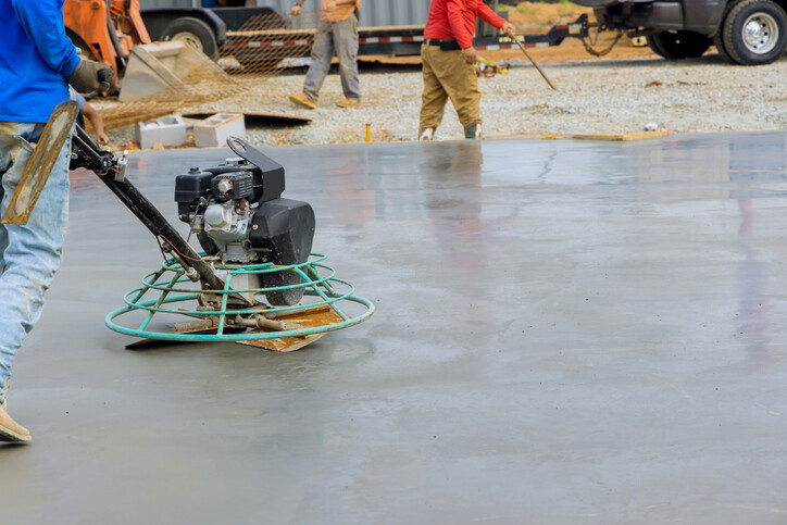 worker smoothing concrete with manual float